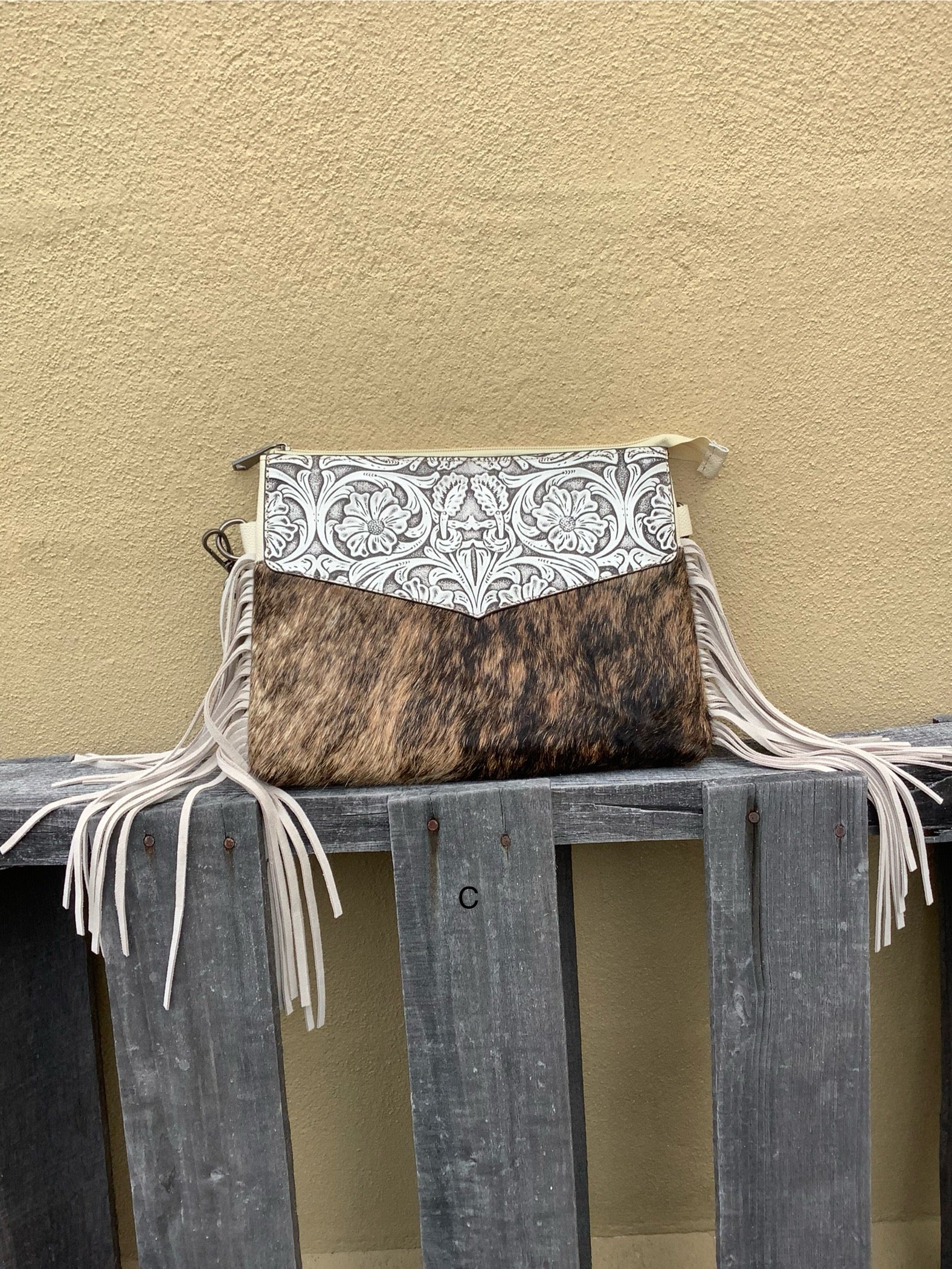 Beige tooled leather and cowhide purse with fringe details and a zippered closure. Front View C