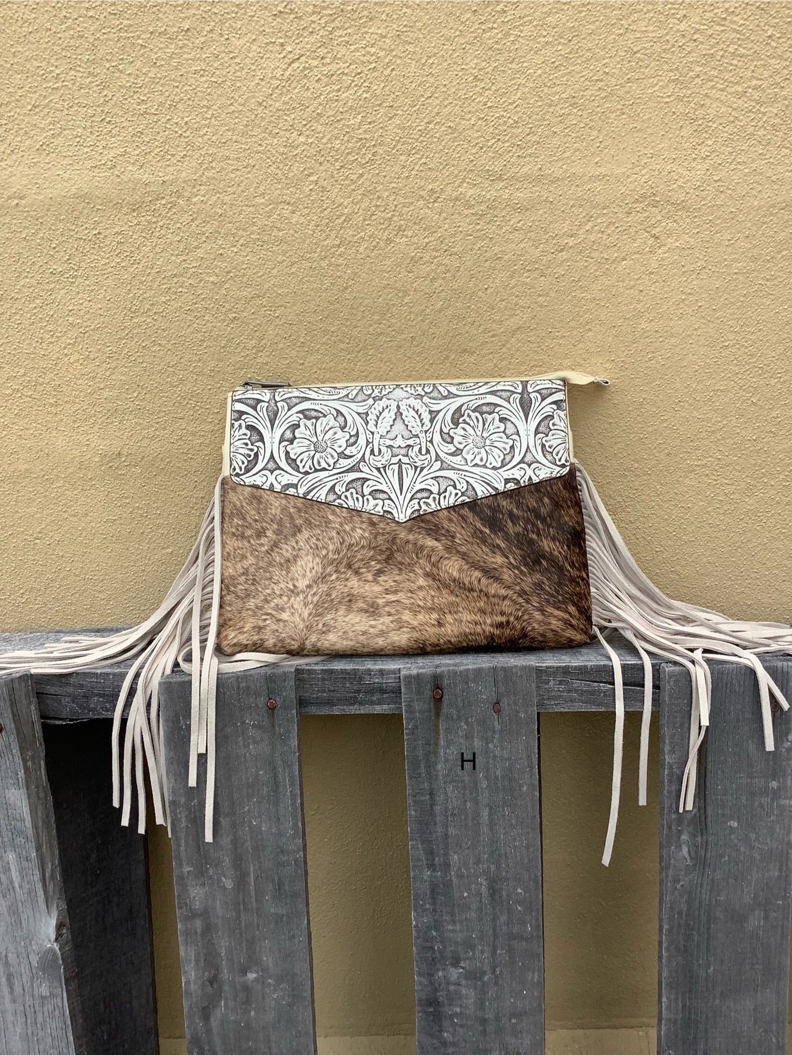 Beige tooled leather and cowhide purse with fringe details and a zippered closure. Front View H