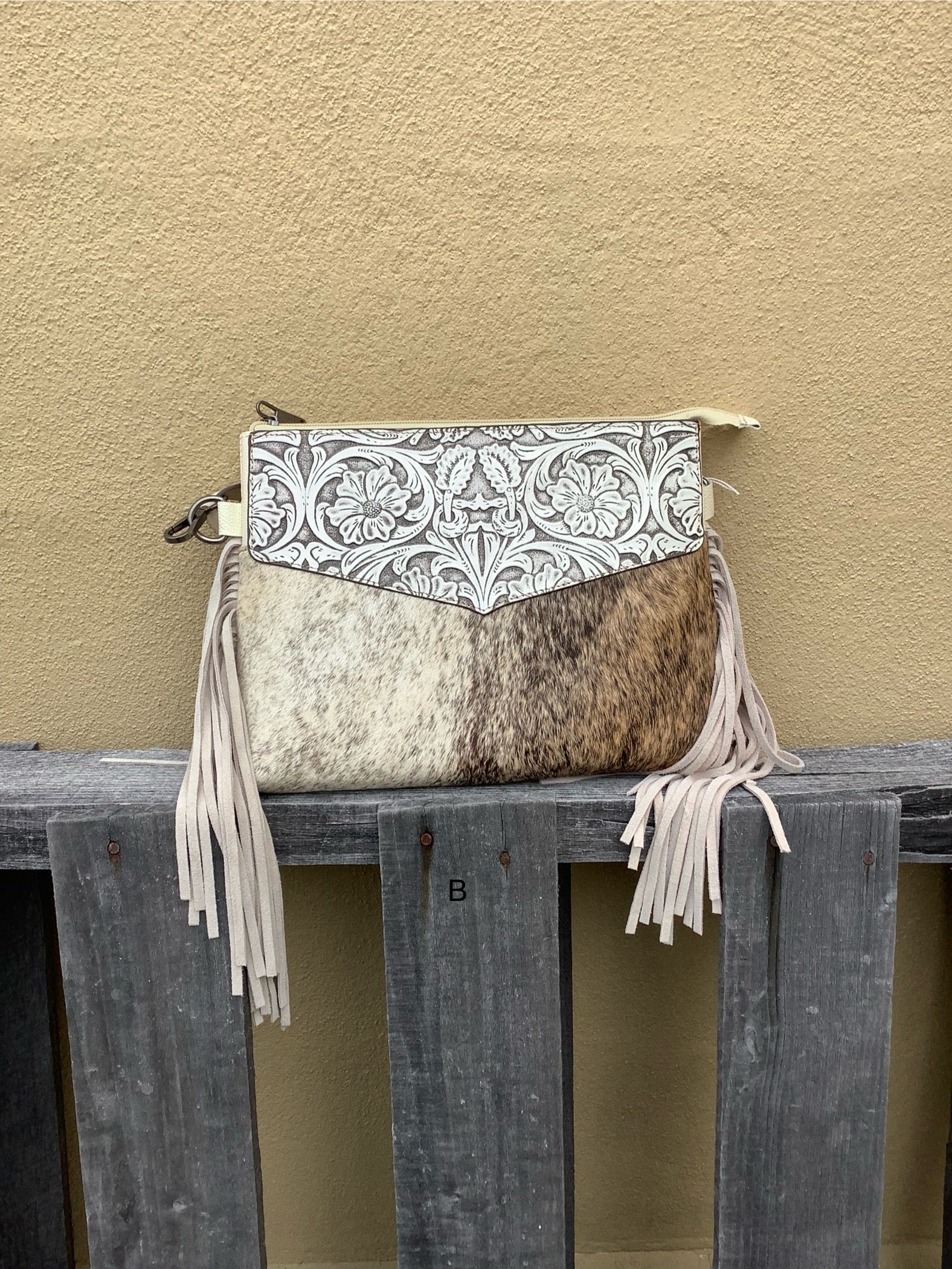 Beige tooled leather and cowhide purse with fringe details and a zippered closure. Front View B