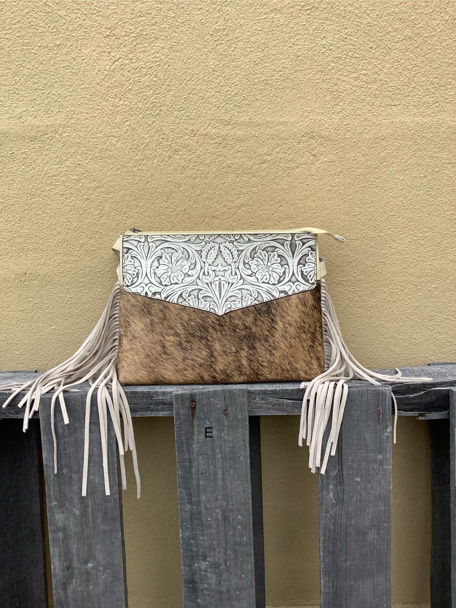 Beige tooled leather and cowhide purse with fringe details and a zippered closure. Front View E