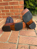 A pair of Anderson Bean square toe boots with rust-colored lux hornback caiman skin and regal blue kidskin tops.  Bottom view showing hybrid outsoles. 