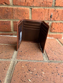 Inside view of pebbled brown leather trifold wallet. 