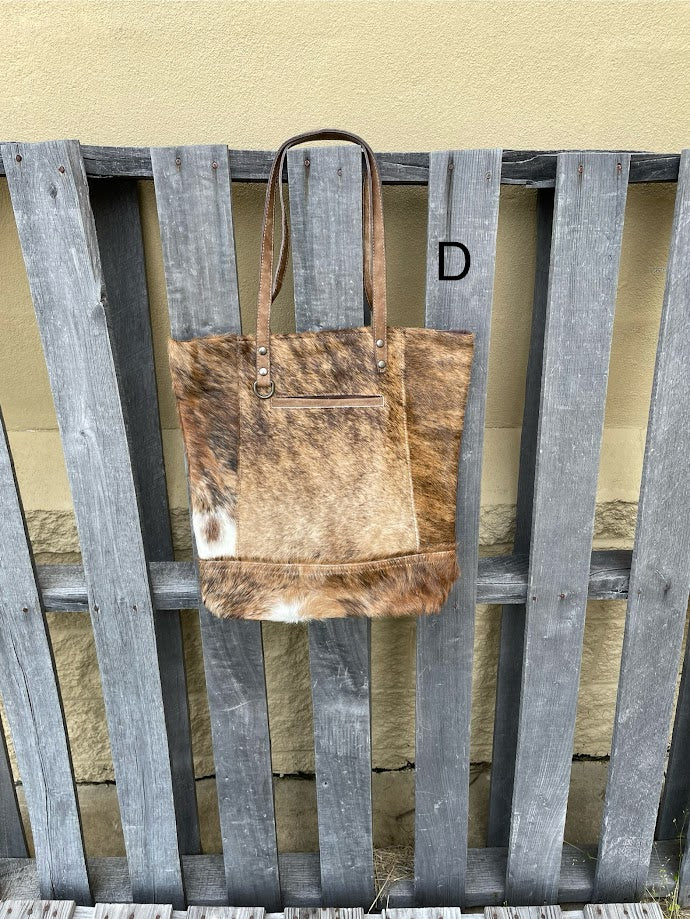 Brown leather and cowhide tote bag with a solid leather back with a concealed carry pocket. Front View D