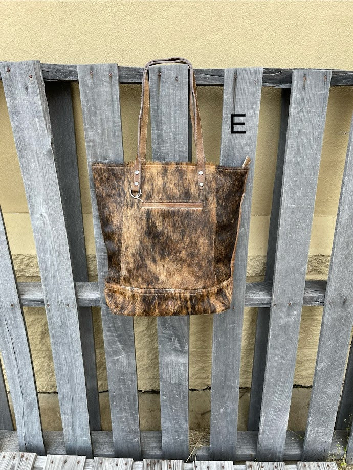 Brown leather and cowhide tote bag with a solid leather back with a concealed carry pocket. Front View E