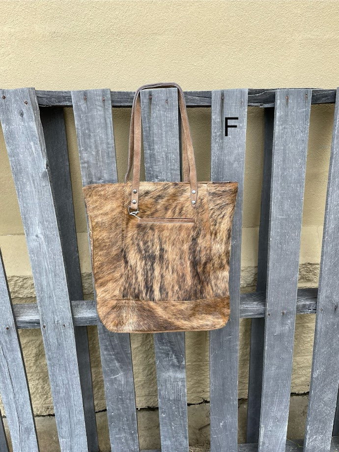 Brown leather and cowhide tote bag with a solid leather back with a concealed carry pocket. Front View F