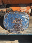 Silver and Gold belt buckle with a Praying Cowboy design and a Gold border with four feathers. 
