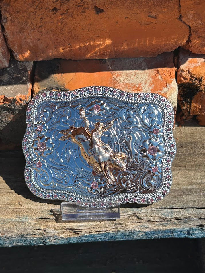 Silver and Gold western style belt buckle with a Bull Rider design and a Pink rhinestone border. 