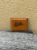 A tan leather money clip with the text 'State' logo embossed on the front.