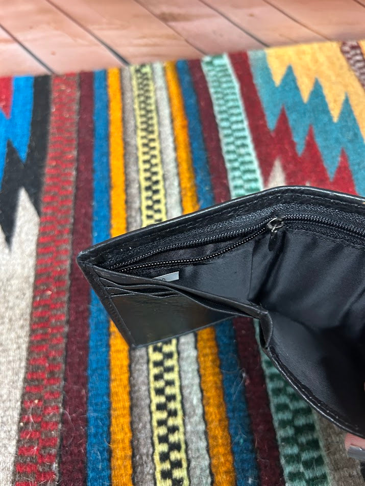 Black leather trifold wallet  with a stich pattern on the top. Interior view of cash close showing zip close. 