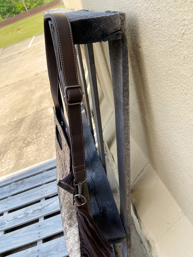 Cowhide and Coffee Brown tooled leather purse with fringe. This bag can be carried by the handle or the removable, adjustable strap. Side view showing strap