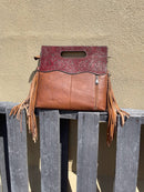 A cowhide and Brown tooled leather purse with fringe. Rear view showing concealed carry pocket. 