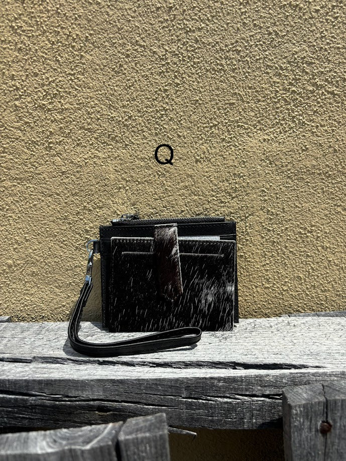 This black leather and cowhide wristlet wallet has six total card slots along with a zippered close pocket. Front View Q