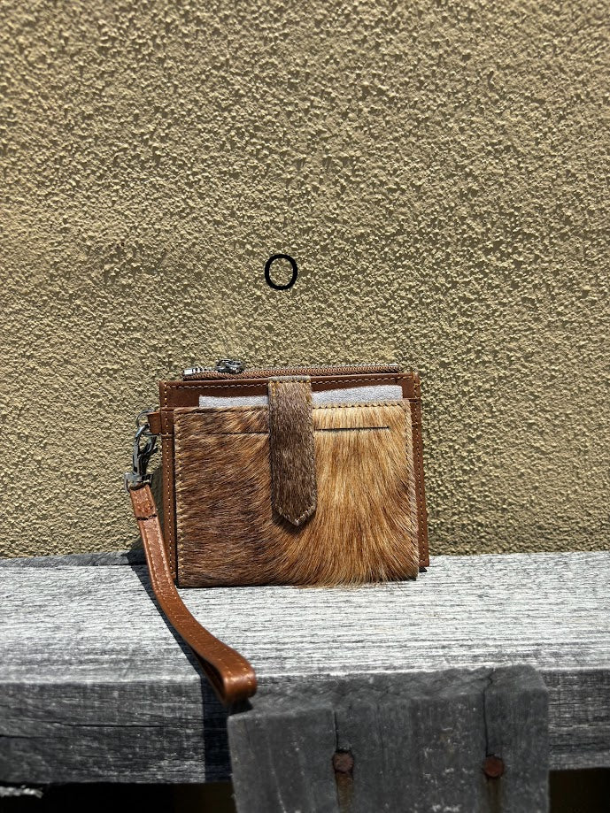 This Brown leather and cowhide wristlet wallet features six total card slots and a zippered pocket. Front View O