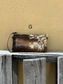 Cowhide wristlet purse with a solid Brown leather back and a zippered closure. It features a wristlet strap and and a adjustable removable shoulder strap. Front View G