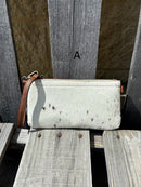 Cowhide wristlet purse with a solid Brown leather back and a zippered closure. It features a wristlet strap and and a adjustable removable shoulder strap. Front View A