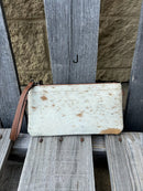 Cowhide wristlet purse with a solid Brown leather back and a zippered closure. It features a wristlet strap and and a adjustable removable shoulder strap. Front View J