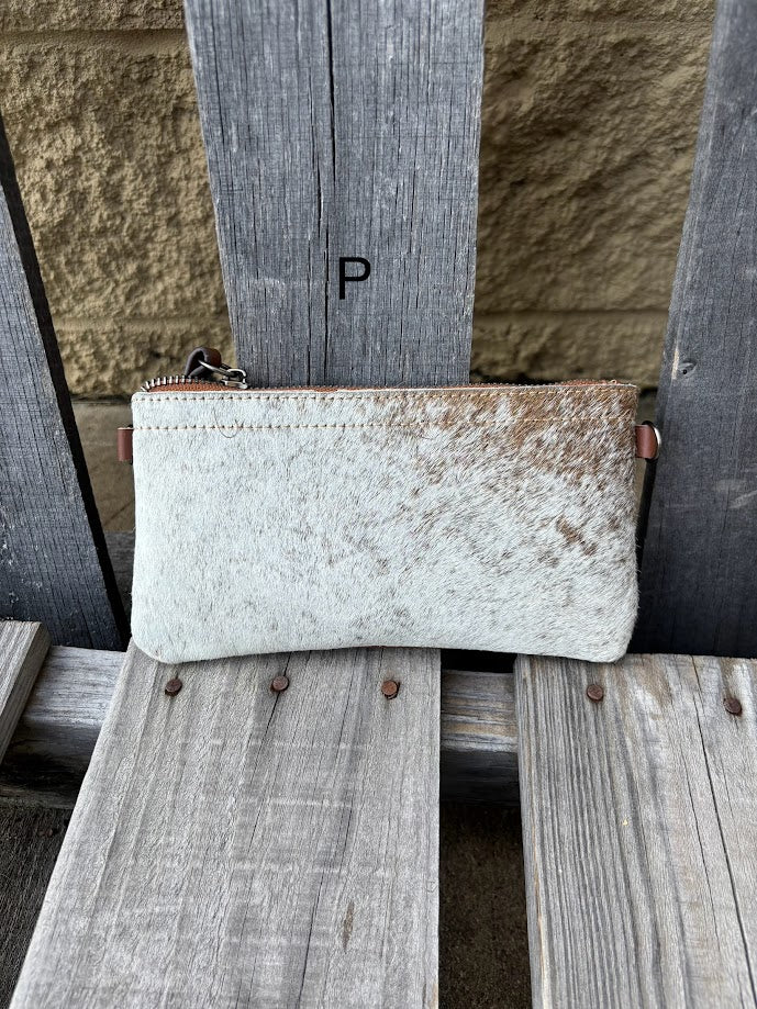Cowhide wristlet purse with a solid Brown leather back and a zippered closure. It features a wristlet strap and and a adjustable removable shoulder strap. Front View P