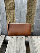 Cowhide wristlet purse with a solid Brown leather back and a zippered closure. It features a wristlet strap and and a adjustable removable shoulder strap. Front View I