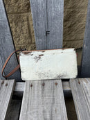 Cowhide wristlet purse with a solid Brown leather back and a zippered closure. It features a wristlet strap and and a adjustable removable shoulder strap. Front View F