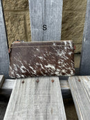 Cowhide wristlet purse with a solid Brown leather back and a zippered closure. It features a wristlet strap and and a adjustable removable shoulder strap. Front View S