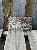 Cowhide wristlet purse with a solid Brown leather back and a zippered closure. It features a wristlet strap and and a adjustable removable shoulder strap. Front View K