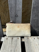 Cowhide wristlet purse with a solid Brown leather back and a zippered closure. It features a wristlet strap and and a adjustable removable shoulder strap. Front View O