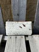 Cowhide wristlet purse with a solid Brown leather back and a zippered closure. It features a wristlet strap and and a adjustable removable shoulder strap. Front View N