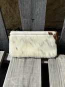 Cowhide wristlet purse with a solid Brown leather back and a zippered closure. It features a wristlet strap and and a adjustable removable shoulder strap. Front View T