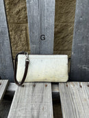 Cowhide wristlet purse in a Coffee Brown solid leather back and a zippered closure. It has a wristlet strap and a removable adjustable shoulder strap. Front View G