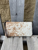 Cowhide wristlet purse in a Coffee Brown solid leather back and a zippered closure. It has a wristlet strap and a removable adjustable shoulder strap. Front View A