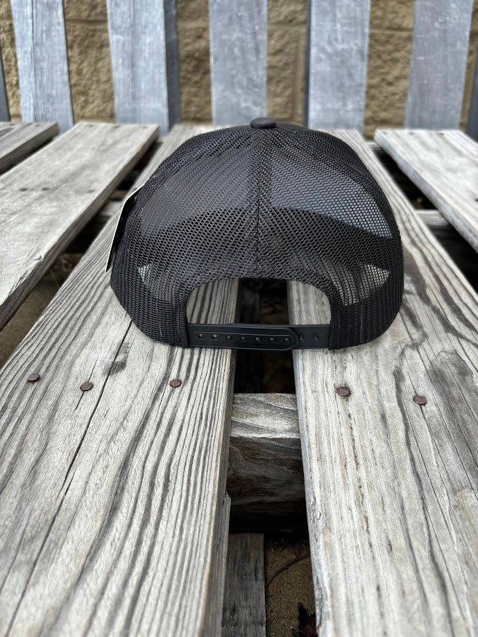 A black snapback cap with a embroidered praying cowboy design. Rear View