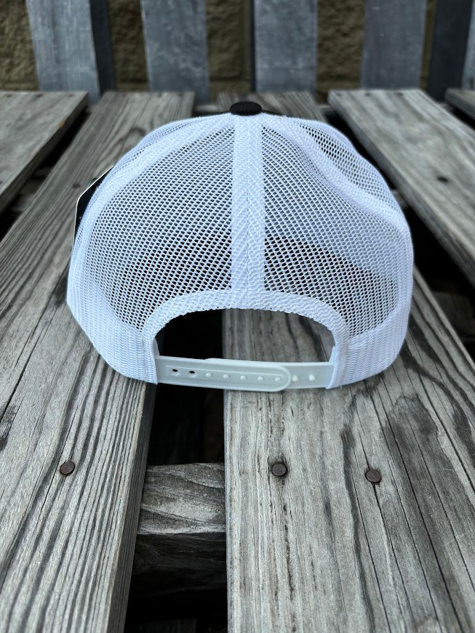 A Black and White snapback cap with a embroidered praying cowboy design on the front. Rear View