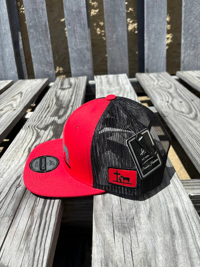 A Red and Black snapback cap with a embroidered praying cowboy design on the front. Side View