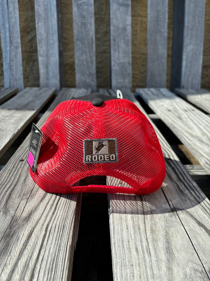 A Black trucker cap with a Red mesh back featuring a 'RODEO' Bull Rider patch on the front. Rear view showing small matching patch on back. 