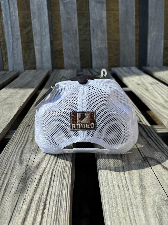 A Black trucker cap with a 
White mesh back featuring a 'RODEO' Bull Rider patch on the front. Rear view showing small matching patch. 