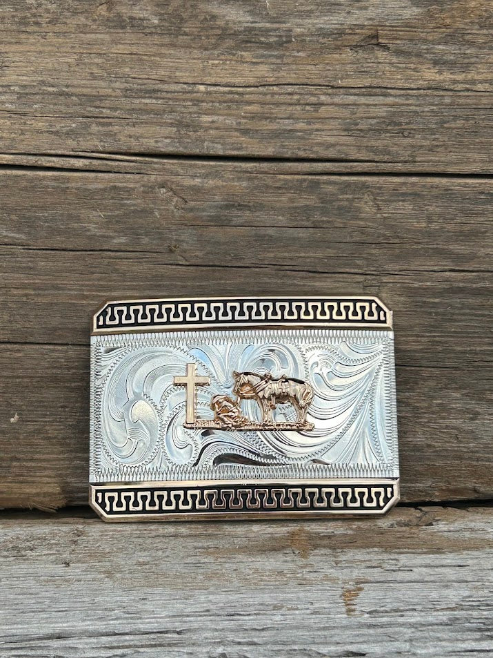 This mixed metal buckle features a Gold Praying Cowboy design on a Silver rectangle featuring a Gold and Black border.  Front View