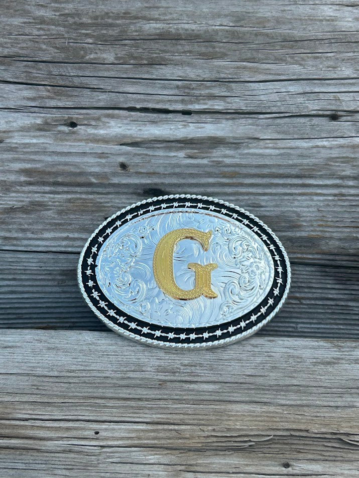 Matte Black and Silver oval shaped belt buckle with Gold initial. Initial G