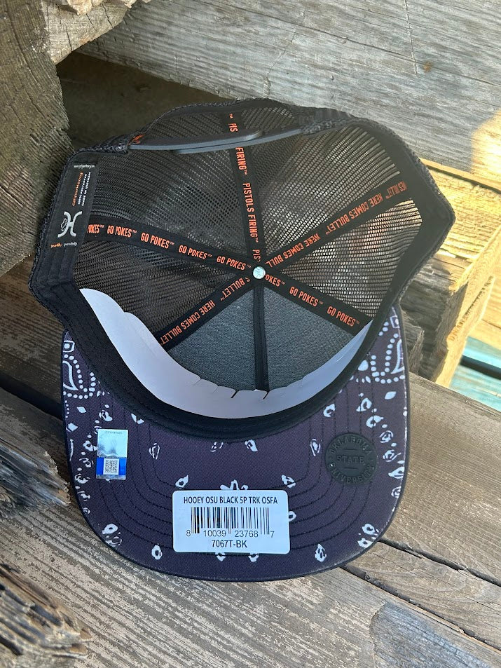 Oklahoma State University Hooey snapback trucker cap. Solid black. mesh back with OSU embroidery. Inside view showing bandana print on bill. 