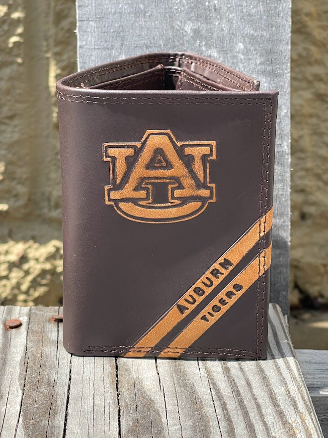 A Zep-Pro brown leather trifold wallet featuring the Auburn University logo near the wallet top in debossed design. Two debossed stripes angled on the bottom right read Auburn Tigers. Front view.