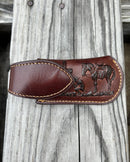 Brown leather knife sheath with a Praying Cowboy design and a keep. Front View