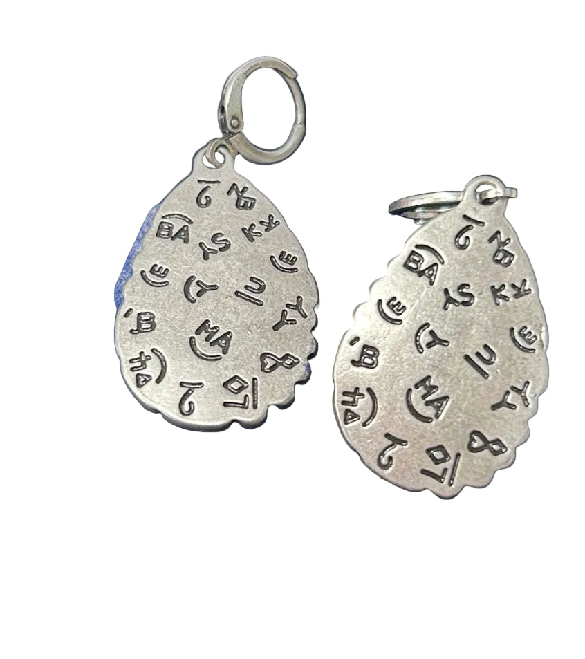Crafted Turquoise teardrop earrings with silver border and a hinged clasp.  Back view showing brand details. 