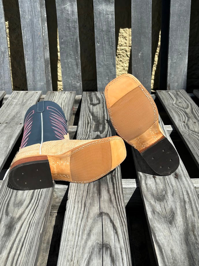 A pair of men's Anderson Bean cowboy boots with tan washed shoulder and a 12" navy upper. Bottom view featuring hybrid outsole. 