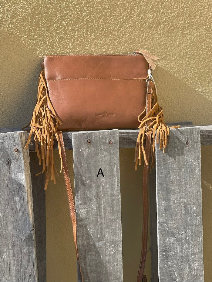 Brown leather and cowhide crossbody bag with side fringe. Rear View