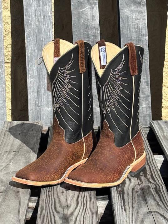 A pair of Anderson Bean 12-inch tan hungry hippo skin boots with black waxy Kansas leather tops. 