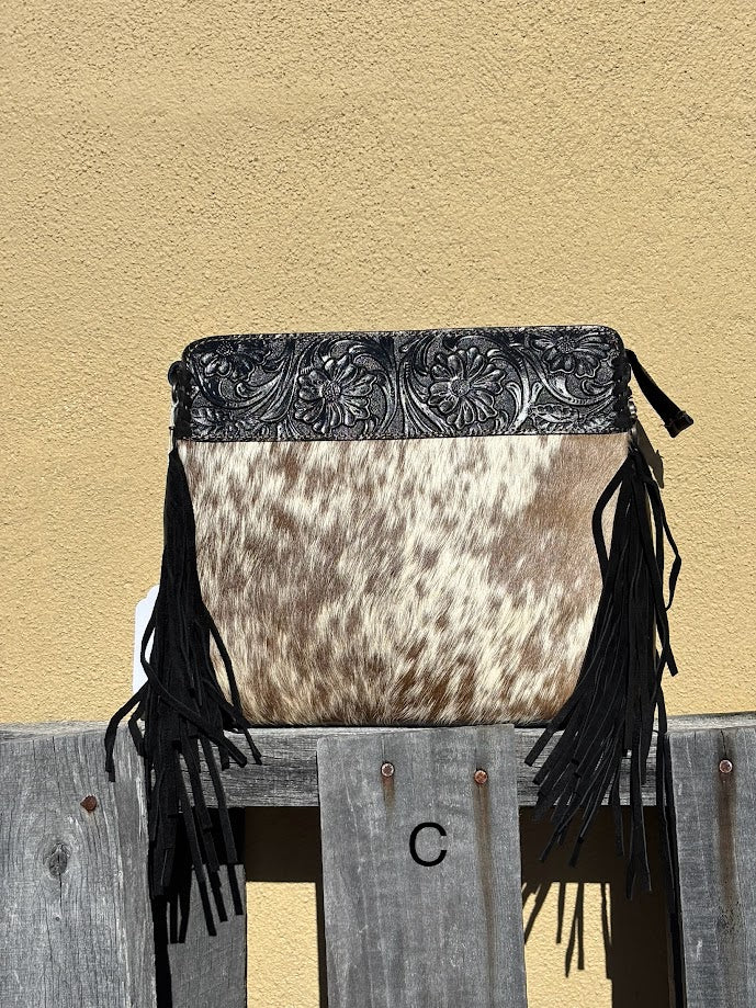Black embossed leather and cowhide crossbody bag with side fringe. This bag features a zippered closed top and a removable, adjustable strap. Front View C