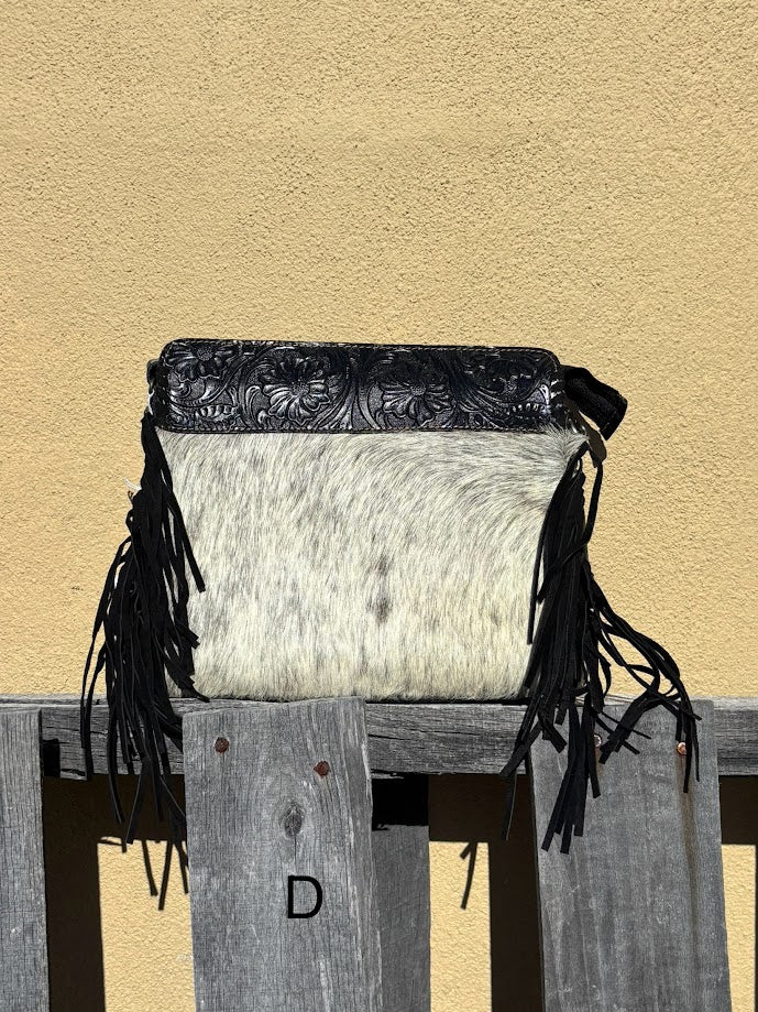 Black embossed leather and cowhide crossbody bag with side fringe. This bag features a zippered closed top and a removable, adjustable strap.  Front View D