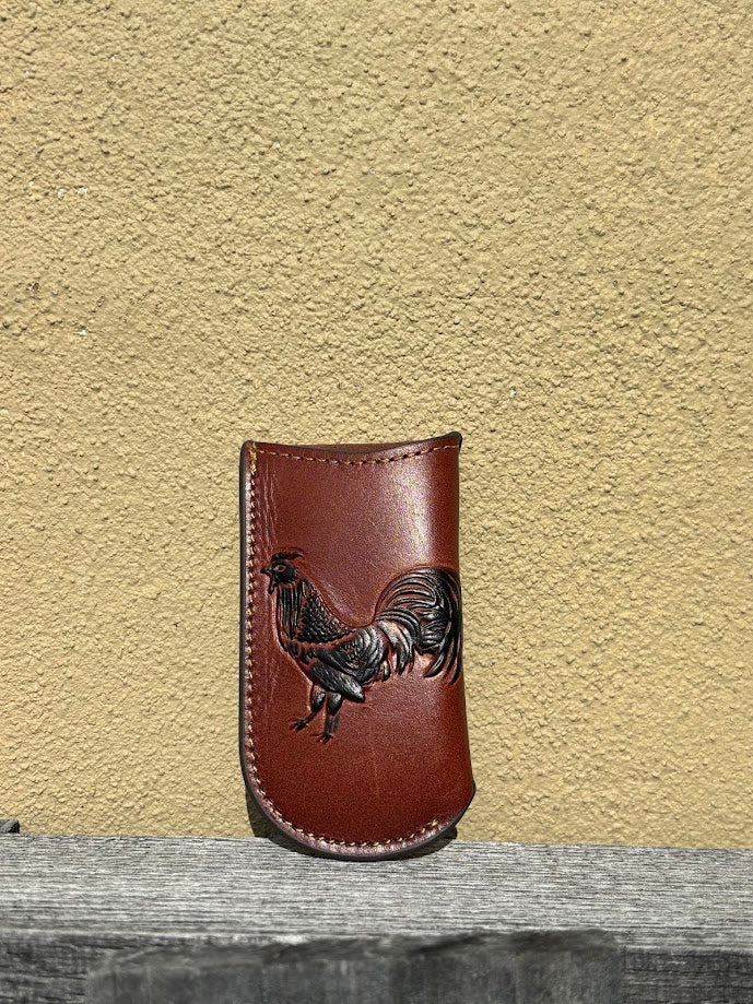 This brown leather knife sheath has a Rooster design and measures 4 1/2 inches tall and 2 1/2 wide. Front View
