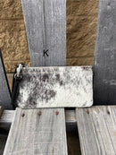 Cowhide wristlet purse in Black leather with a zippered closure. This bag has a wristlet handle or shoulder strap. Front View K