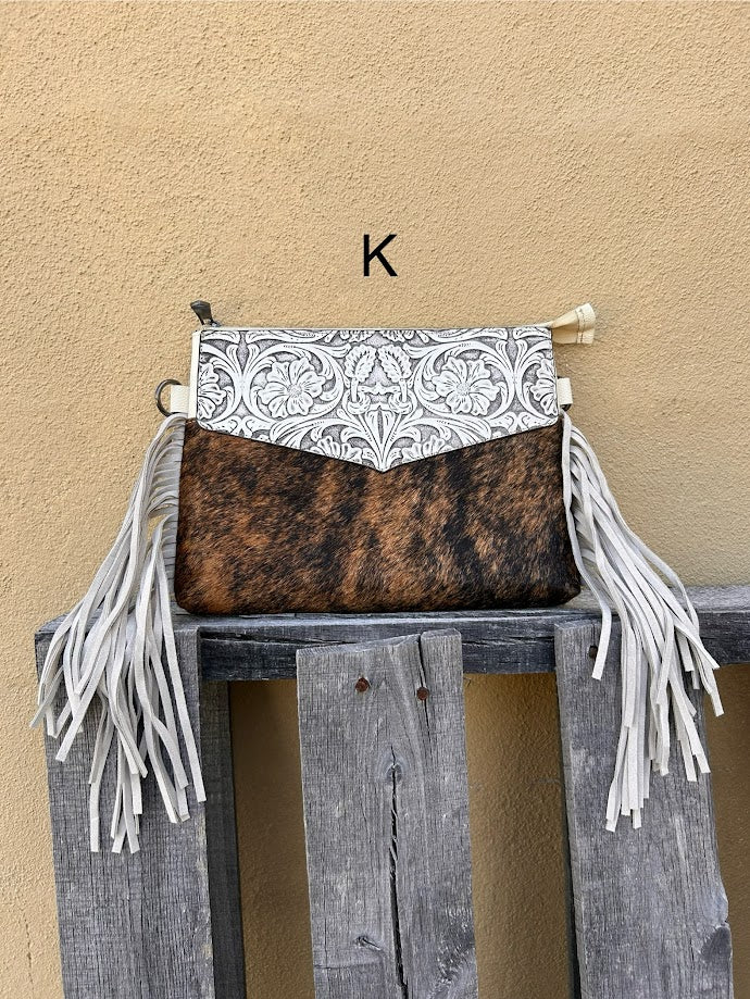 Beige tooled leather and cowhide purse with fringe details and a zippered closure. Front View K
