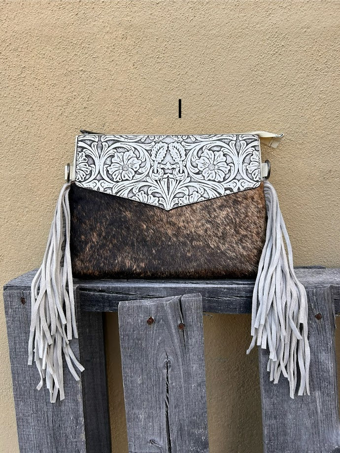 Beige tooled leather and cowhide purse with fringe details and a zippered closure. Front View I